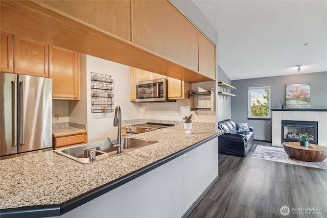 1707 NW 59th St Unit 302, Seattle, WA 98107 - kitchen featuring stainless steel appliances, dark wood-style floors, open floor plan, a fireplace, and a peninsula