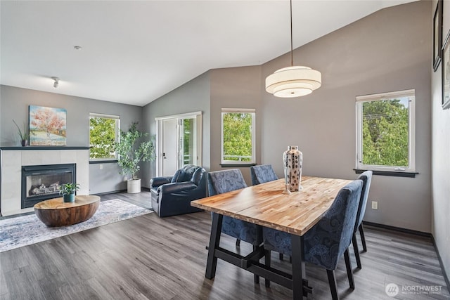 1707 NW 59th St Unit 302, Seattle, WA 98107 - dining room with lofted ceiling, healthy amount of natural light, wood finished floors, and a tile fireplace