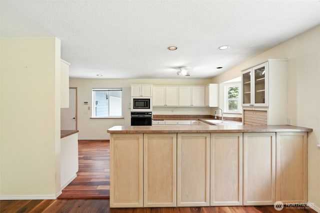 116 Noble Rd, Winlock, WA 98596 - kitchen with built in microwave, oven, glass insert cabinets, a peninsula, and dark wood-style floors