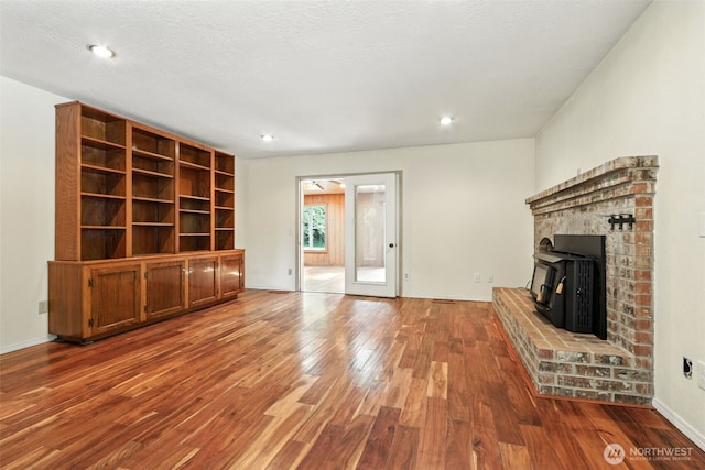116 Noble Rd, Winlock, WA 98596 - unfurnished living room with wood finished floors, a wood stove, and recessed lighting