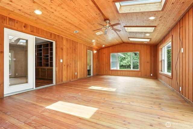 116 Noble Rd, Winlock, WA 98596 - spare room featuring a skylight, light wood finished floors, vaulted ceiling, wooden walls, and a ceiling fan