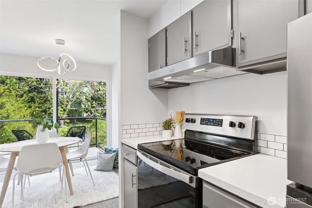 19414 Aurora Ave N Unit 203, Shoreline, WA 98133 - kitchen featuring appliances with stainless steel finishes, under cabinet range hood, light countertops, gray cabinets, and a chandelier