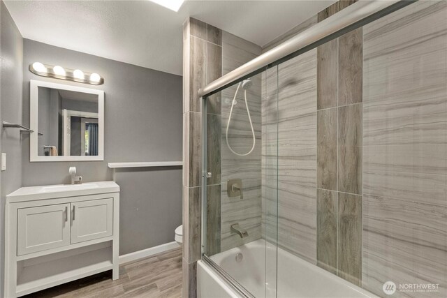 12027 78th Ave S, Seattle, WA 98178 - full bathroom with vanity, bath / shower combo with glass door, and wood finished floors
