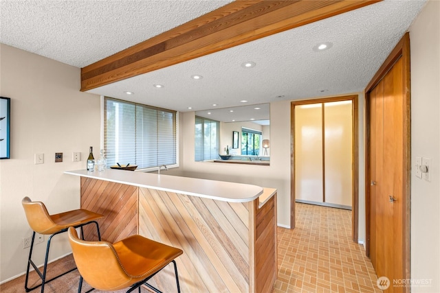 818 179th Pl NE, Bellevue, WA 98008 - kitchen with a kitchen breakfast bar, a peninsula, a textured ceiling, light countertops, and recessed lighting