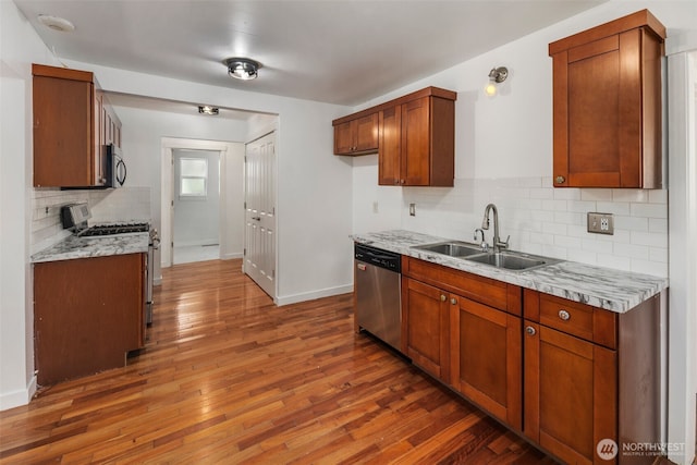 2033 E Wright Ave, Tacoma, WA 98404 - kitchen with stainless steel appliances, wood-type flooring, tasteful backsplash, and brown cabinets