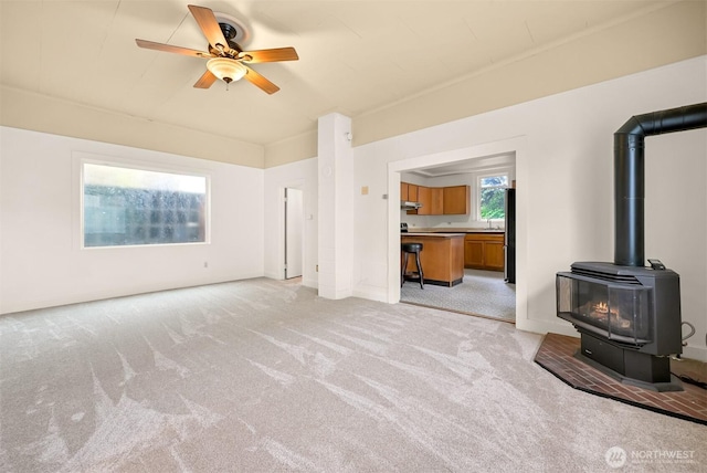 1609 F St, Bellingham, WA 98225 - unfurnished living room featuring light carpet, ceiling fan, and a wood stove