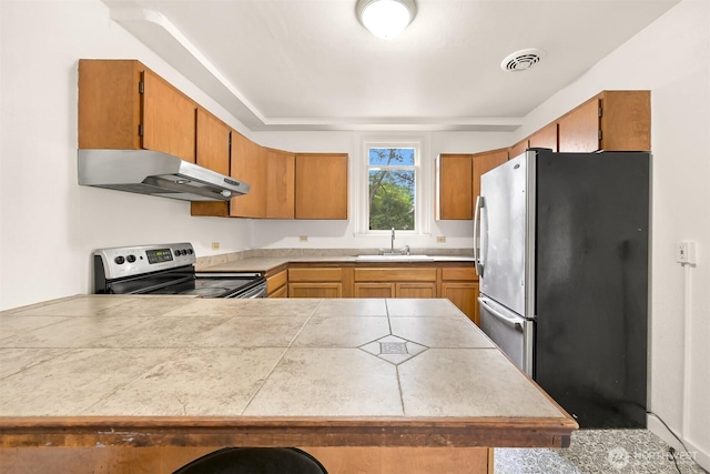 1609 F St, Bellingham, WA 98225 - kitchen featuring stainless steel appliances, under cabinet range hood, a peninsula, and brown cabinetry