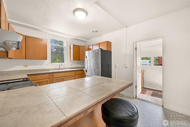 1609 F St, Bellingham, WA 98225 - kitchen featuring freestanding refrigerator, ventilation hood, a peninsula, brown cabinetry, and a breakfast bar