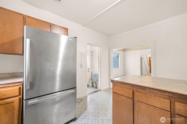 1609 F St, Bellingham, WA 98225 - kitchen featuring freestanding refrigerator, tile counters, and brown cabinetry