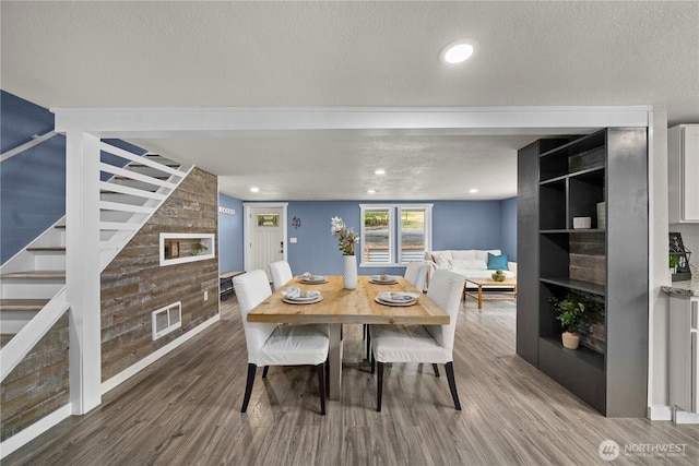 4415 Waller Rd E, Tacoma, WA 98443 - dining space featuring a fireplace, wood finished floors, stairs, and a textured ceiling