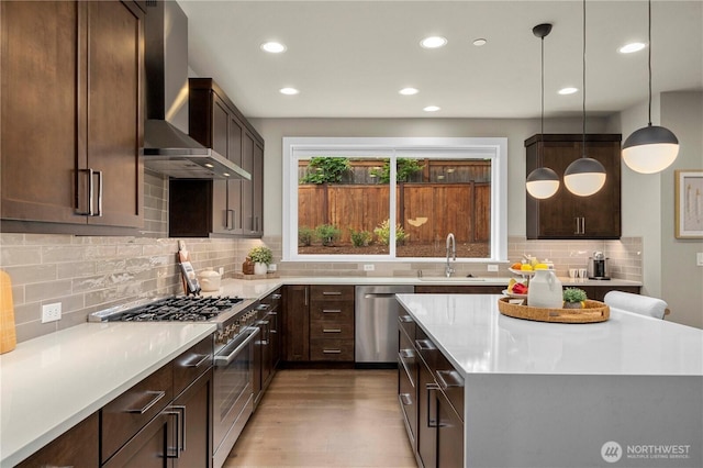 10259 133rd Ct NE, Redmond, WA 98033 - kitchen featuring appliances with stainless steel finishes, wall chimney exhaust hood, recessed lighting, light wood-style flooring, and tasteful backsplash