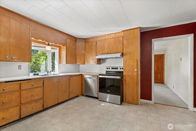 18056 25th Ave NE, Lake Forest Park, WA 98155 - kitchen with stainless steel appliances, under cabinet range hood, brown cabinets, light countertops, and light floors