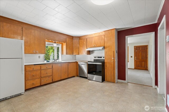 18056 25th Ave NE, Lake Forest Park, WA 98155 - kitchen featuring stainless steel appliances, under cabinet range hood, light countertops, and brown cabinetry