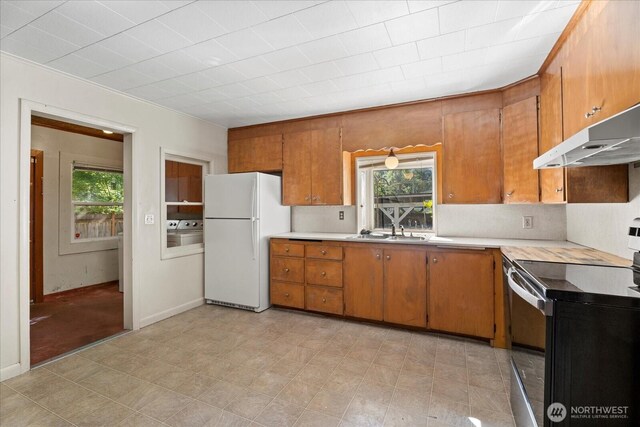 18056 25th Ave NE, Lake Forest Park, WA 98155 - kitchen with electric range, freestanding refrigerator, under cabinet range hood, and brown cabinets