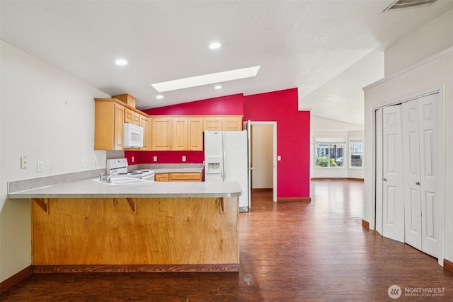 87 Chickadee Dr, Kelso, WA 98626 - kitchen featuring white appliances, a skylight, vaulted ceiling, a peninsula, and dark wood-style floors