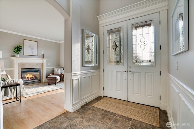 1425 S Sunset Dr, Tacoma, WA 98465 - foyer entrance with a decorative wall, a fireplace, arched walkways, wainscoting, and ornamental molding