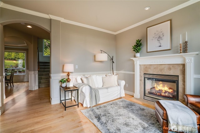 1425 S Sunset Dr, Tacoma, WA 98465 - living room with arched walkways, wood finished floors, a tile fireplace, crown molding, and a wainscoted wall