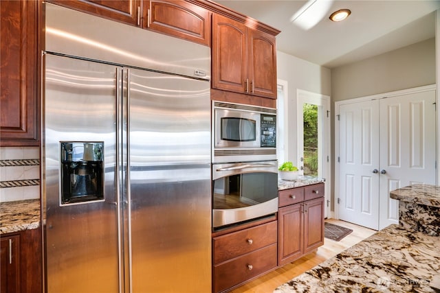 1425 S Sunset Dr, Tacoma, WA 98465 - kitchen with built in appliances, light stone countertops, and light wood finished floors