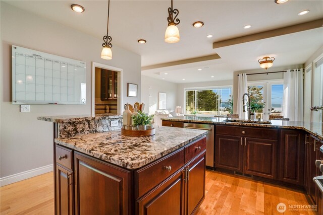1425 S Sunset Dr, Tacoma, WA 98465 - kitchen featuring dishwasher, a center island, light stone countertops, light wood-style floors, and recessed lighting