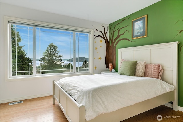 1425 S Sunset Dr, Tacoma, WA 98465 - bedroom with wood finished floors and a water view