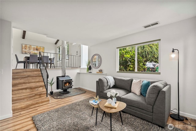 4209 S 297th Pl, Auburn, WA 98001 - living room featuring wood finished floors, a wood stove, and stairs