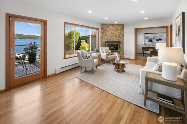 13190 Riviera Pl NE, Seattle, WA 98125 - living area with baseboard heating, a fireplace, light wood-style floors, recessed lighting, and a water view