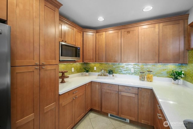 13190 Riviera Pl NE, Seattle, WA 98125 - kitchen with stainless steel appliances, brown cabinets, backsplash, light countertops, and recessed lighting