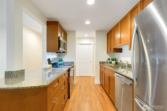 21307 48th Ave W Unit C211, Mountlake Terrace, WA 98043 - kitchen with appliances with stainless steel finishes, brown cabinets, light wood-style flooring, light stone countertops, and recessed lighting