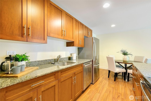 21307 48th Ave W Unit C211, Mountlake Terrace, WA 98043 - kitchen featuring stainless steel appliances, brown cabinetry, light wood-style flooring, light stone countertops, and recessed lighting