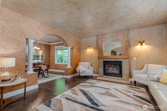 1122 36th Ave NE, Olympia, WA 98506 - living room featuring hardwood / wood-style floors, arched walkways, a tile fireplace, and ornate columns