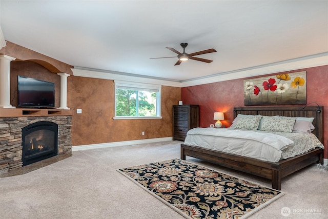 1122 36th Ave NE, Olympia, WA 98506 - carpeted bedroom with decorative columns, a stone fireplace, and ceiling fan