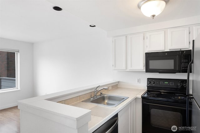 2727 E Franklin Ave E Unit 102, Seattle, WA 98102 - kitchen featuring black appliances, white cabinets, a peninsula, light countertops, and light wood-style flooring