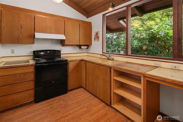 kitchen featuring electric range, under cabinet range hood, light countertops, lofted ceiling, and brown cabinetry