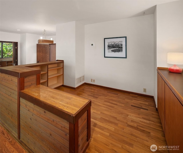 unfurnished living room with wood finished floors and baseboards