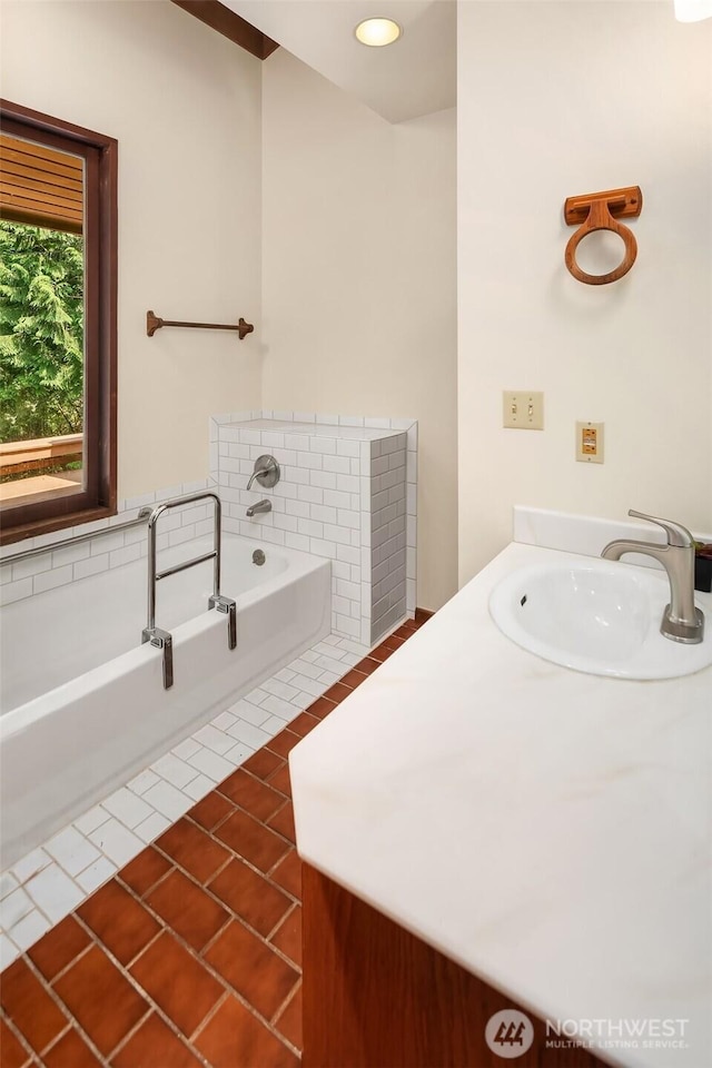 full bathroom featuring a garden tub, tile patterned floors, and vanity