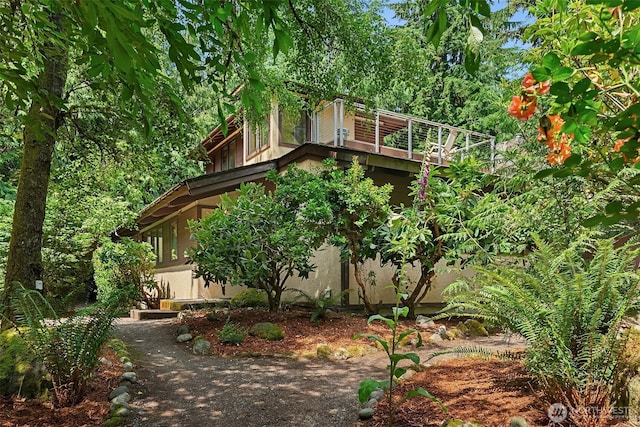 view of home's exterior with stucco siding and a wooden deck