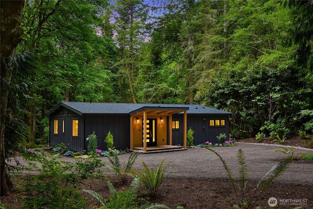 1524 Toe Jam Hill Rd NE, Bainbridge Island, WA 98110 - view of front facade featuring board and batten siding, a porch, and a forest view