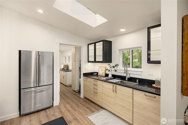 1524 Toe Jam Hill Rd NE, Bainbridge Island, WA 98110 - kitchen featuring high quality fridge, dark countertops, a skylight, light wood-type flooring, and glass insert cabinets