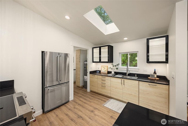 1524 Toe Jam Hill Rd NE, Bainbridge Island, WA 98110 - kitchen featuring high end refrigerator, dark countertops, a skylight, vaulted ceiling, and light wood-type flooring