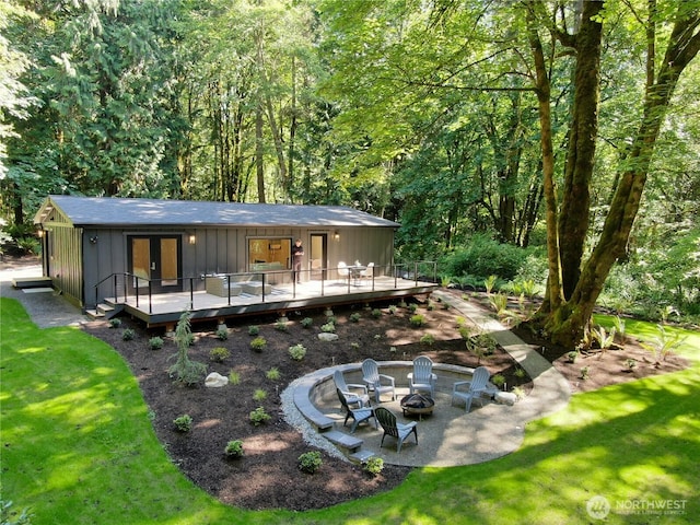 1524 Toe Jam Hill Rd NE, Bainbridge Island, WA 98110 - rear view of house featuring an outdoor fire pit, a deck, board and batten siding, a yard, and french doors