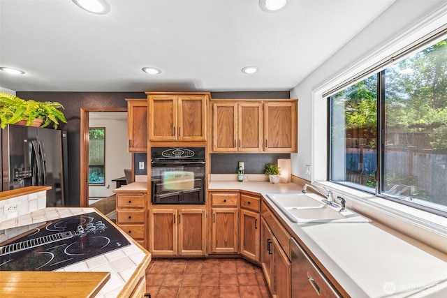 5040 Mill Pond Loop SE, Auburn, WA 98092 - kitchen featuring black appliances, recessed lighting, light tile patterned floors, tile counters, and brown cabinetry