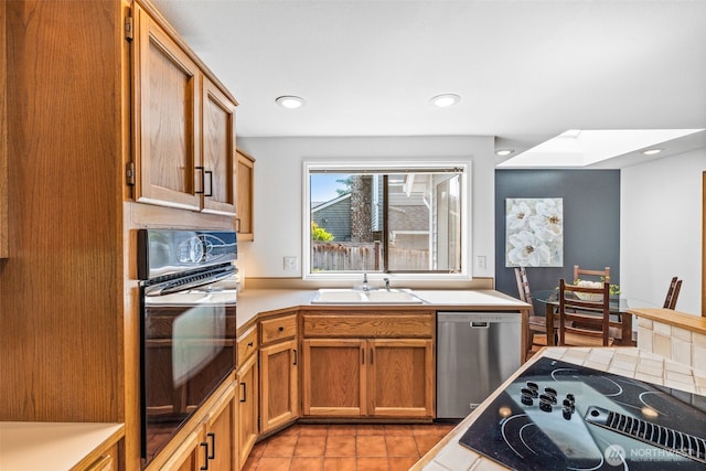 5040 Mill Pond Loop SE, Auburn, WA 98092 - kitchen with black appliances, light countertops, light tile patterned flooring, a skylight, and brown cabinets