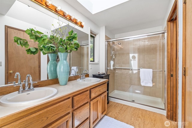 5040 Mill Pond Loop SE, Auburn, WA 98092 - bathroom featuring double vanity, a stall shower, wood finished floors, and a skylight