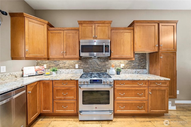 4119 72nd St E, Tacoma, WA 98443 - kitchen featuring stainless steel appliances, backsplash, brown cabinetry, and light stone counters