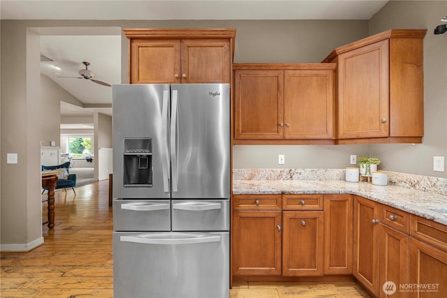 4119 72nd St E, Tacoma, WA 98443 - kitchen with stainless steel fridge, light wood-type flooring, a ceiling fan, light stone countertops, and brown cabinets