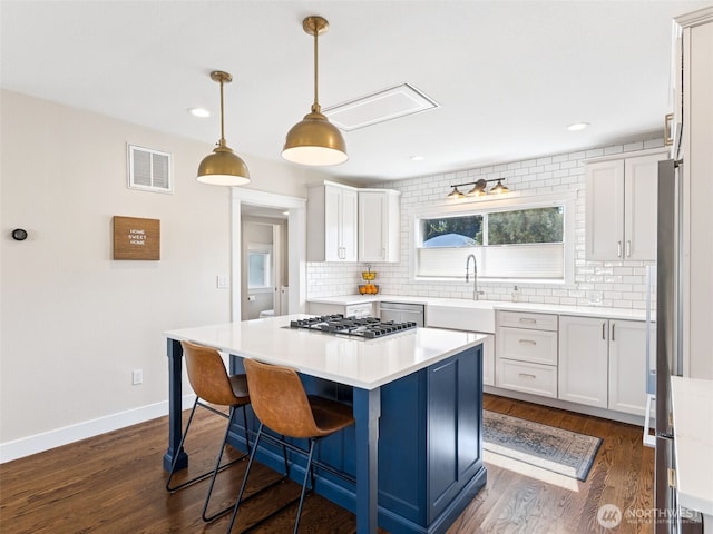 724 6th Ave SW, Puyallup, WA 98371 - kitchen featuring appliances with stainless steel finishes, tasteful backsplash, a center island, white cabinetry, and recessed lighting