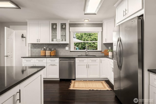 1321 Kossuth Ave, Everett, WA 98203 - kitchen with stainless steel appliances, dark wood-style flooring, dark countertops, and tasteful backsplash