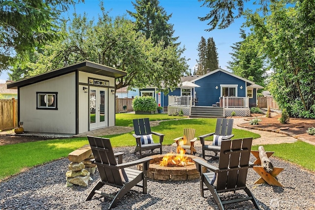 1321 Kossuth Ave, Everett, WA 98203 - view of yard with an outdoor fire pit, a wooden deck, an outbuilding, and french doors
