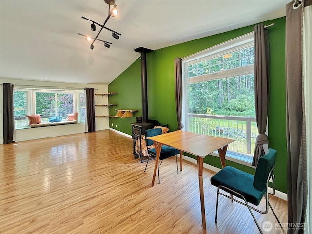 11422 Leschi Cir, Anderson Island, WA 98303 - dining room featuring a wood stove, healthy amount of natural light, lofted ceiling, and light wood finished floors