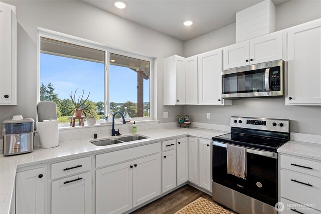 1575 Kingsley Ave, Blaine, WA 98230 - kitchen with appliances with stainless steel finishes, dark wood-style flooring, white cabinetry, and recessed lighting